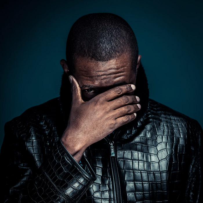 portrait artistique en studio, d'un homme sur fond bleu.