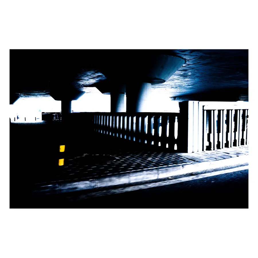 Point de vue architectural sous un pont de Pékin, avec ses garde-corps illuminés créant une perspective onirique, très contrasté.