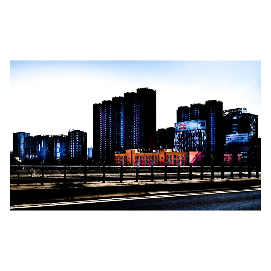 Immeubles pékinois illuminés de néons bleus, vision alternative de l'architecture nocturne urbaineavec la photo réalisée à partir de la fenêtre d'une voiture.