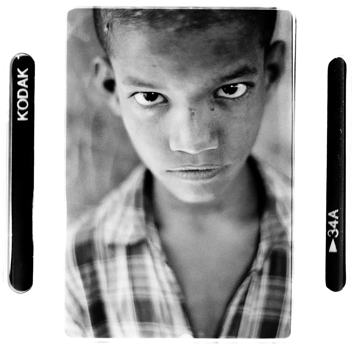 Portrait d'un enfant des rues regard vers la camera en Inde pour une photographie sociale.