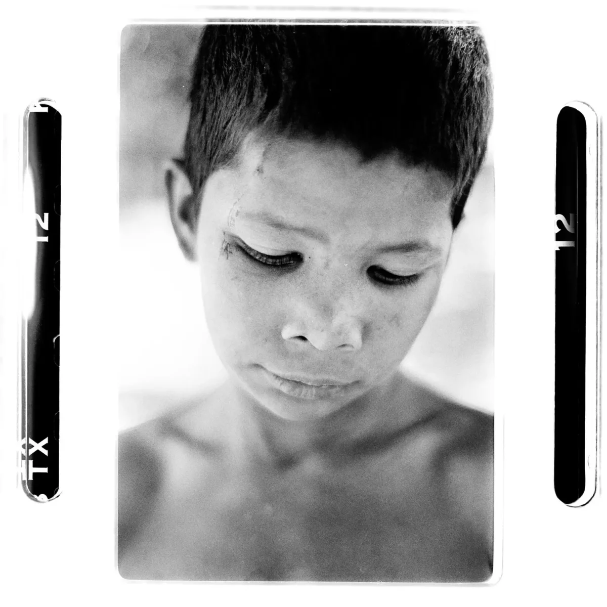 Portrait d'un enfant des rues pensif, regard vers le bas en introspection eb Inde pour une photographie sociale.