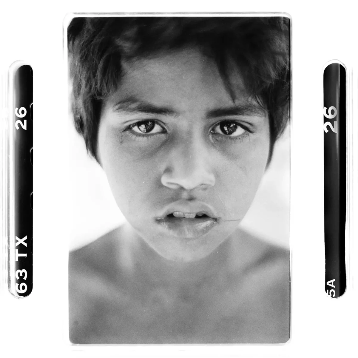 Portrait d'un garçon des rues au regard intense en Inde, photographie en noir et blanc.
