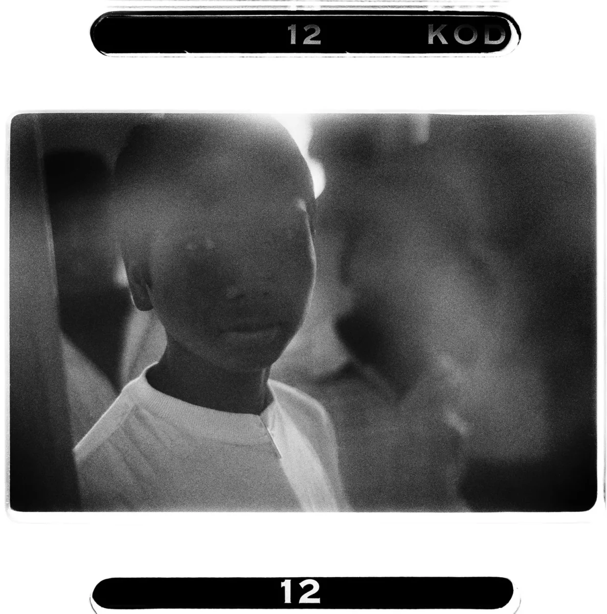 Portrait rapproché au regard intime d'un enfant des rues enInde pour une photographie humaniste en noir et blanc.