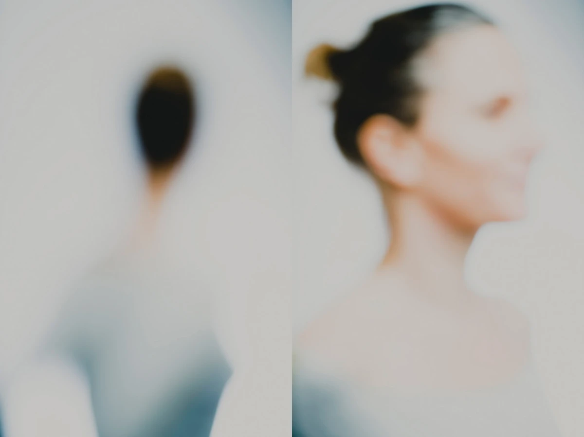 Photographie défocalisée en diptyque : à gauche, nuque et chignon très flous ; à droite, buste et profil féminin sur fond clair, rendu high-key, contours dissous — série « Erasure ».