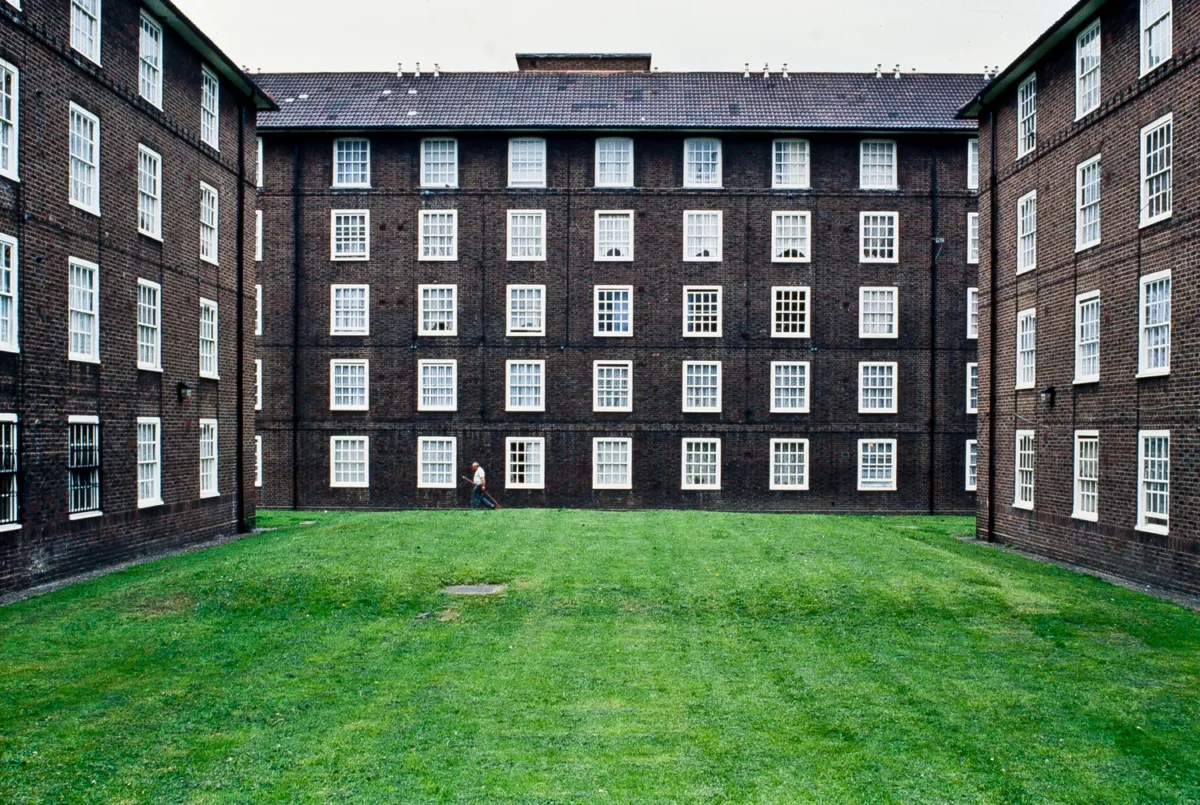 Photographie d’architecture d’une cour intérieure entourée d’immeubles en briques avec fenêtres blanches, prise par un photographe professionnel à Londres.