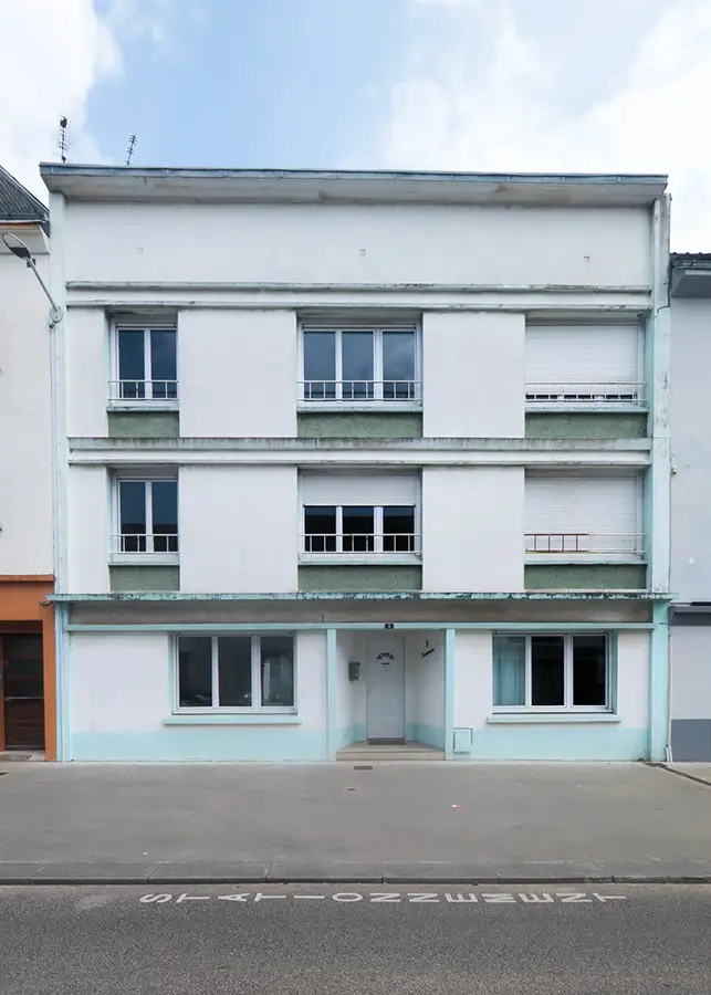 Photographie d’architecture d’une façade d’immeuble urbain aux lignes modernes et couleurs pastel, réalisée à Saint Nazaire.