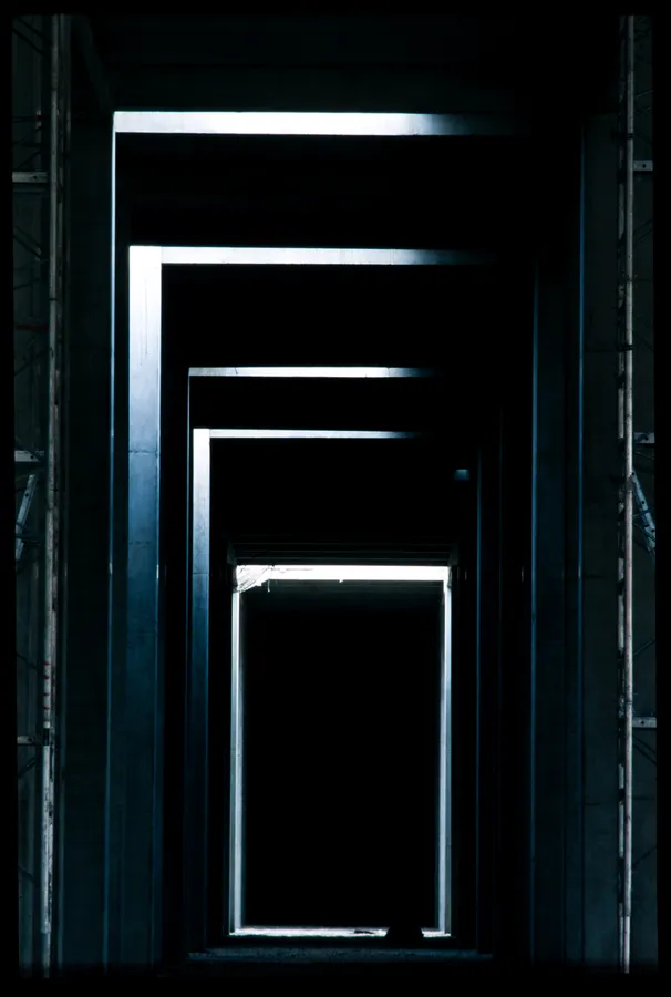 Photographie d’architecture mettant en valeur une succession d’ouvertures métalliques formant une perspective graphique dans un espace industriel, réalisée par un photographe professionnel à Roissy.