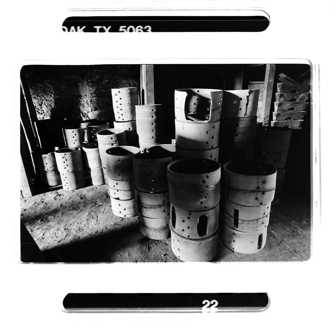 Photographie noir et blanc de pièces de poterie cylindriques et ajourées stockées dans un atelier au poët-laval (Drôme), réalisée dans le cadre d’un reportage sur la poterie traditionnelle du village et la terre blanche locale.