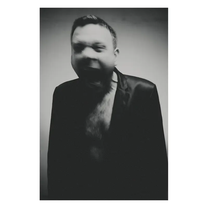 Portrait d'homme en costume noir avec un travail photographique en studio sur la gestuelle du corps à la manière du cri du munch, esthétique minimaliste noir et blanc.