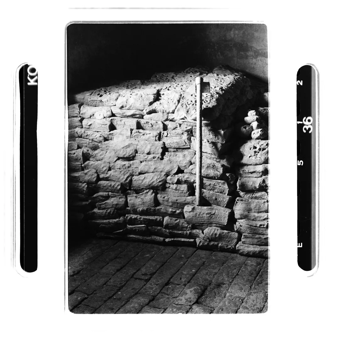 Photo noir et blanc d’un stock de terre glaise blanche locale au poët-laval (Drôme) avec un outil appuyé contre la paroi, réalisée dans le cadre d’un reportage photographique sur la poterie traditionnelle du village.