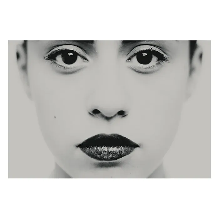 Photographie en très gros plan centrée sur les yeux et le regard, travail plastique sur l'intensité et la frontalité, détail d'un portrait en studio noir et blanc de la série Unvarnished par Nicolas Louis.