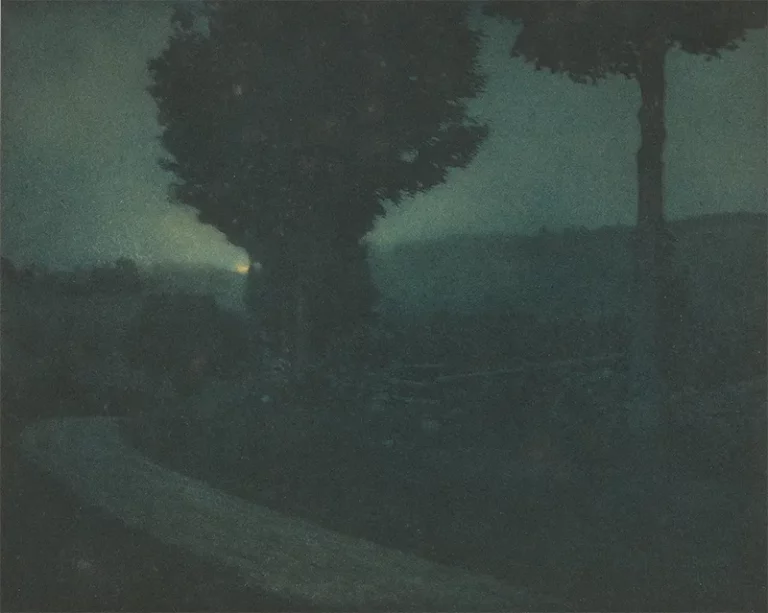 Photographie pictorialiste d'Edward Steichen représentant une route sinueuse dans un vallon sous la lueur d'un clair de lune, aux tons vert et bleu profonds.