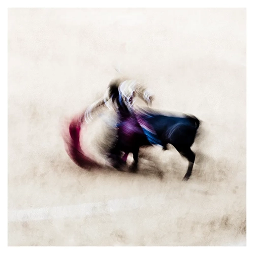 Corrida, flou de mouvement, torero et taureau, tons chauds et cape colorée, réalisé à Bayonne en 2011, inspiré par le photographe Ernst Haas par Nicolas Louis.