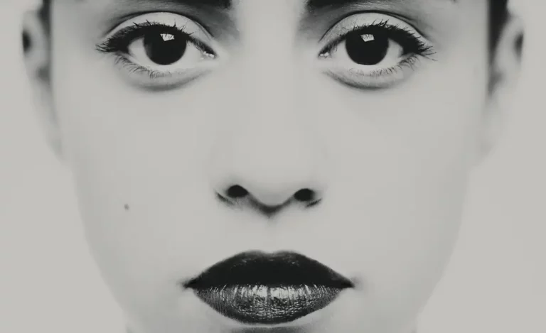 Portrait en studio photo, en noir et blanc d'un visage féminin, en assez gros plan sur les eux et la bouche, illustrant l'article sur l'histoire visuelle en photographie.