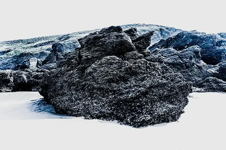 Falaises et rochers noirs saillants au bord de l’estran à Belle-Île-en-Mer. Vision plasticienne de la photographie avec cette série "Welcome to Mars", réalisée par le photographe Nicolas Louis.