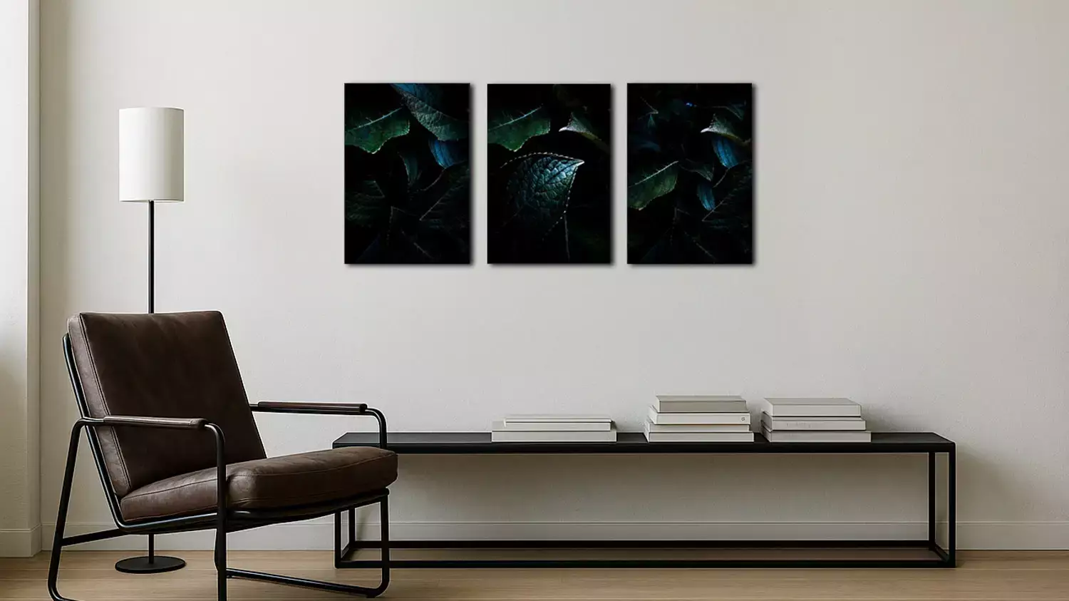 Triptyque de feuilles sombres en tirages fine-art sur mur minimaliste.