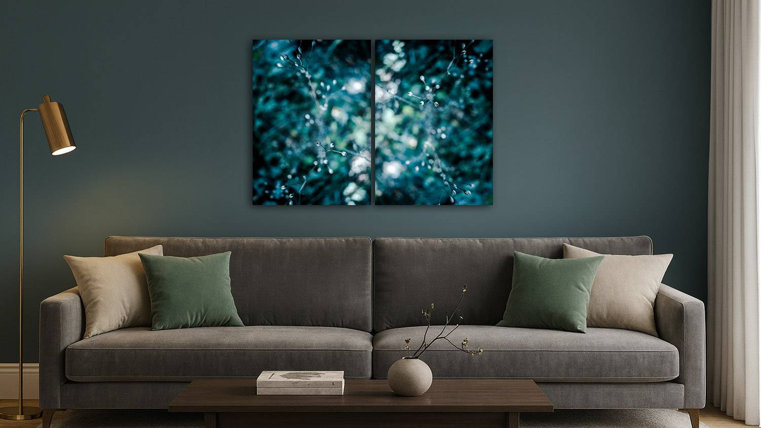 Mockup de diptyque photographique d’art végétal abstrait en bokeh bleu-vert accroché au-dessus d’un canapé gris dans un salon contemporain aux murs bleu profond, ambiance élégante et apaisante.
